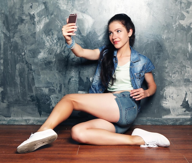 Mujer hermosa joven que hace la foto del selfie en smartphone