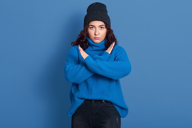 Mujer hermosa joven que lleva el suéter caliente y el sombrero.