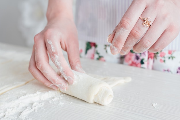 Mujer hermosa joven que prepara los cruasanes caseros