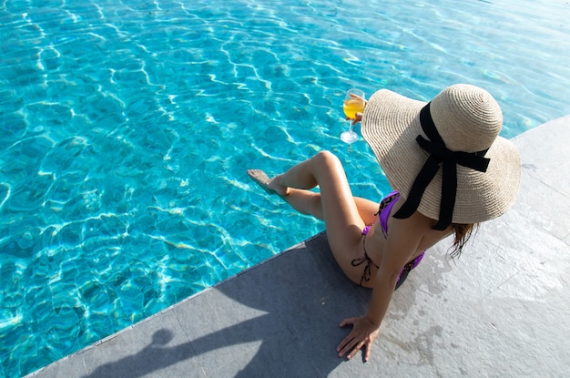 Mujer hermosa joven que se relaja en la piscina en el balneario.