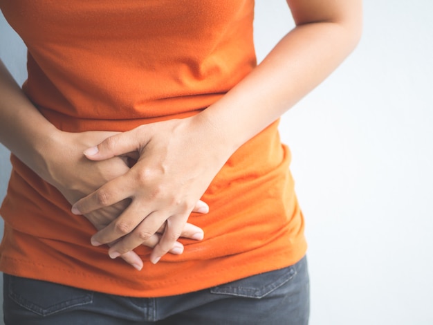 Mujer hermosa joven que tiene dolor de estómago doloroso. Gastritis crónica. Concepto de hinchazón del abdomen.