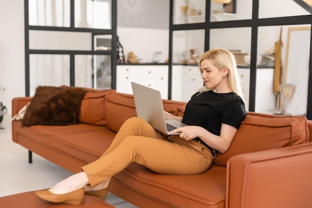 mujer hermosa joven que usa una computadora portátil en casa.