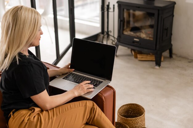 mujer hermosa joven que usa una computadora portátil en casa.