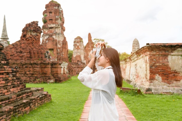 Mujer hermosa joven que viaja y que toma la foto en el parque histórico tailandés