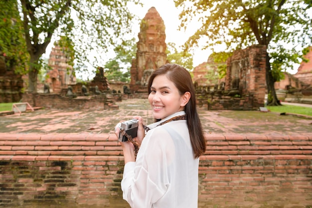 Mujer hermosa joven que viaja y que toma la foto en el parque histórico tailandés