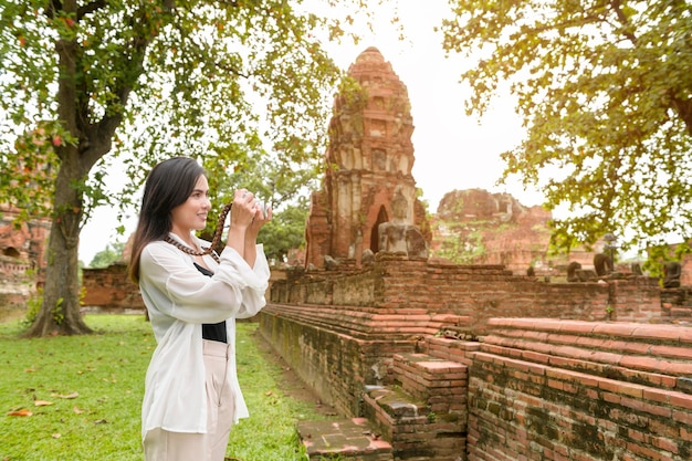 Mujer hermosa joven que viaja y que toma la foto en el parque histórico tailandés