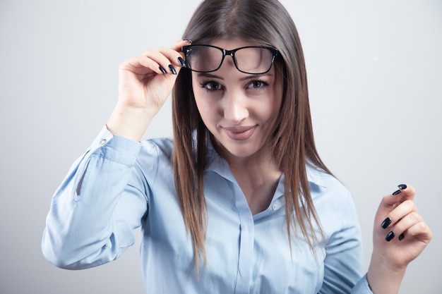 Mujer hermosa joven quitándose las gafas.