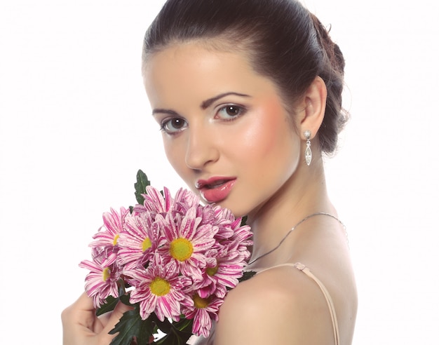 Mujer hermosa joven con ramo de flores rosadas