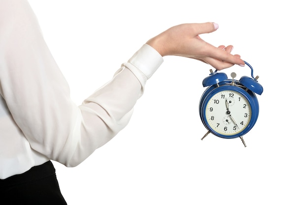 Mujer hermosa joven con el reloj contra el fondo blanco.