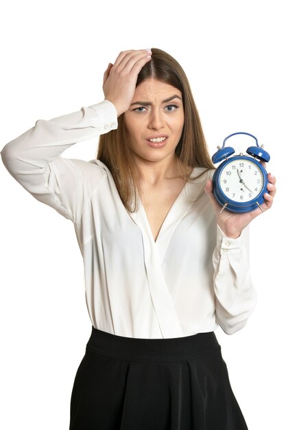 Foto mujer hermosa joven con el reloj contra el fondo blanco.