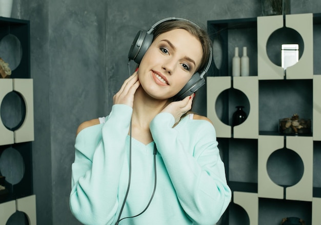 Mujer hermosa joven en ropa casual disfrutando de la música en casa Tecnología de estilo de vida y concepto de personas