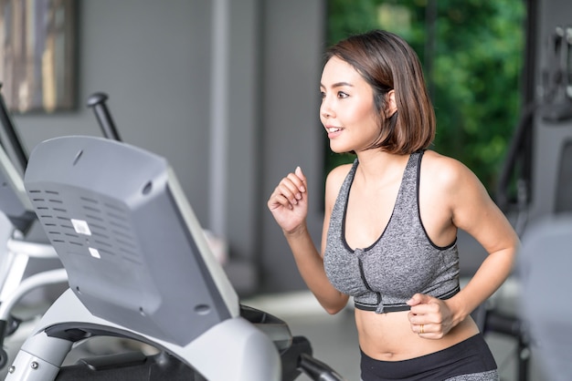 Mujer hermosa joven en la ropa de deportes que se resuelve en gimnasio