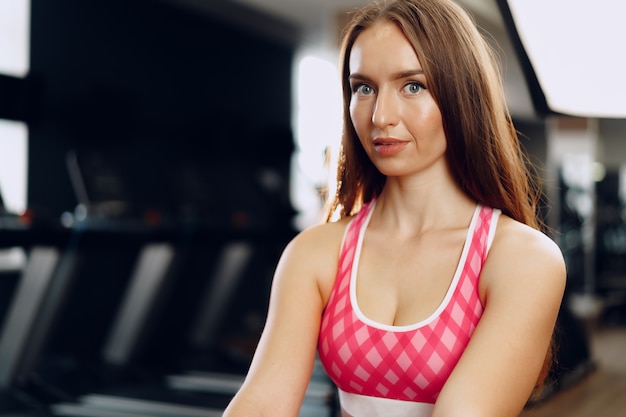 Mujer hermosa joven en ropa deportiva en un gimnasio