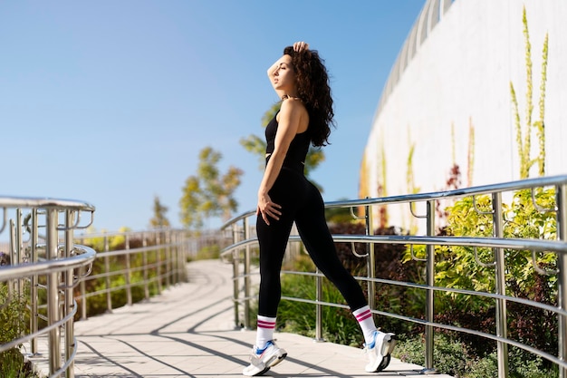 Mujer hermosa joven en ropa deportiva mirando a la calle