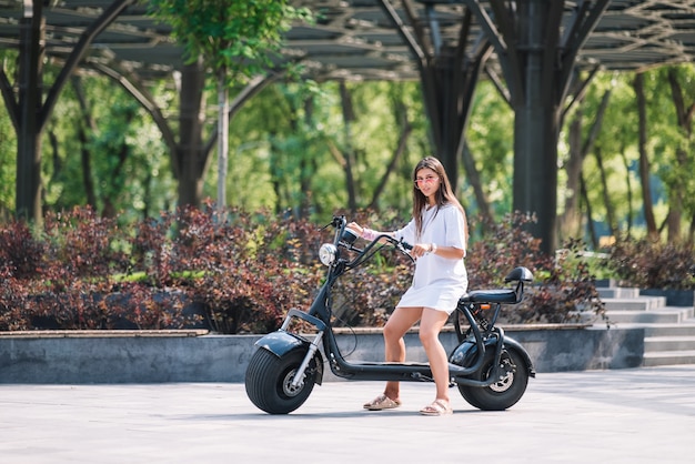 Mujer hermosa joven y un scooter eléctrico