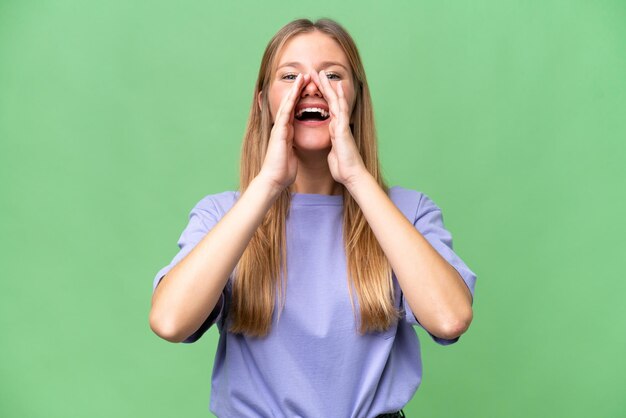 Mujer hermosa joven sobre fondo aislado gritando y anunciando algo