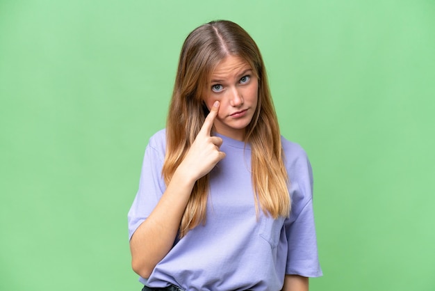 Mujer hermosa joven sobre fondo aislado mostrando algo