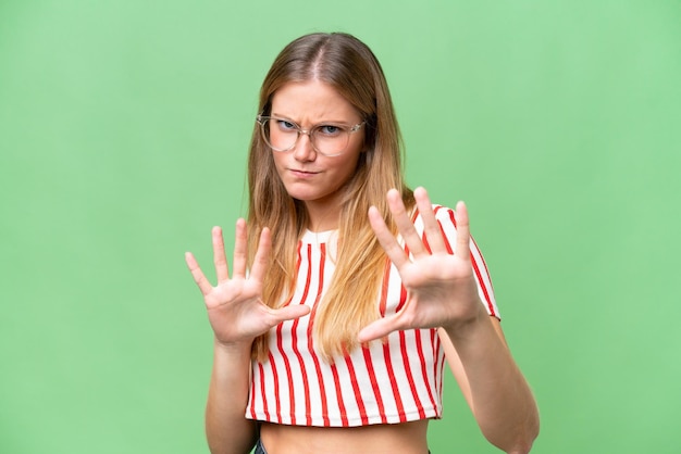 Mujer hermosa joven sobre fondo aislado nervioso estirando las manos al frente