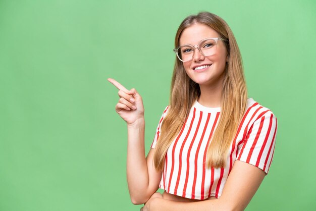 Mujer hermosa joven sobre fondo aislado señalando con el dedo al lado