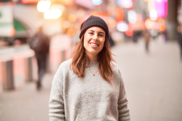 Mujer hermosa joven sonriendo feliz y confiada. De pie con una sonrisa en la cara caminando por la ciudad