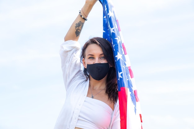 Foto mujer hermosa joven sosteniendo la bandera de estados unidos