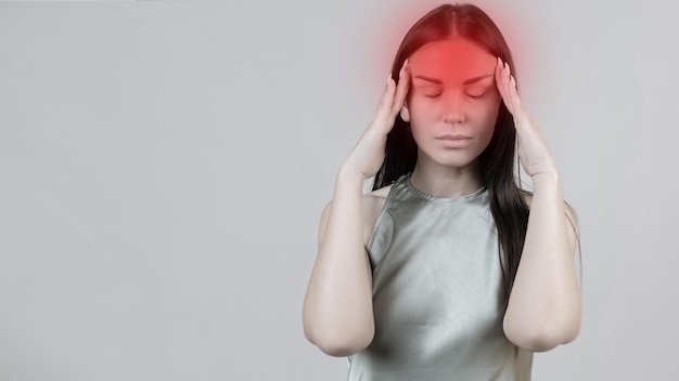 Foto mujer hermosa joven tiene dolor de cabeza aislado sobre fondo gris retrato de niña agotada