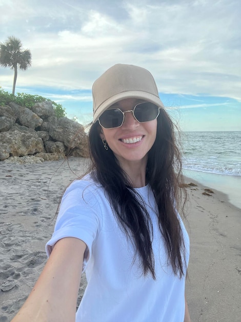 Mujer hermosa joven tomando selfie en la playa