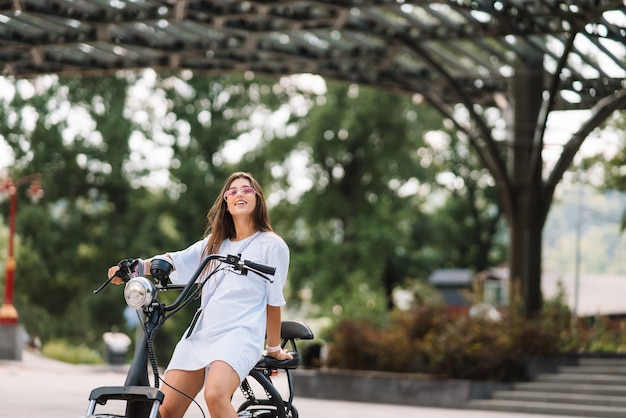 Mujer hermosa joven y un transporte ecológico scooter eléctrico