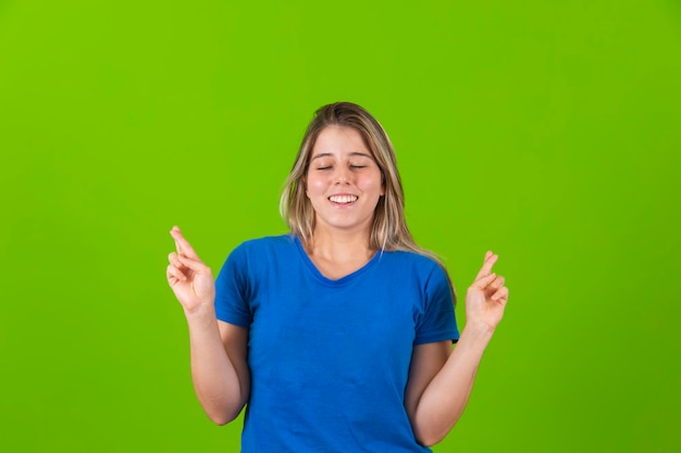 Mujer hermosa joven vestida con ropa casual con los dedos cruzados deseando suerte