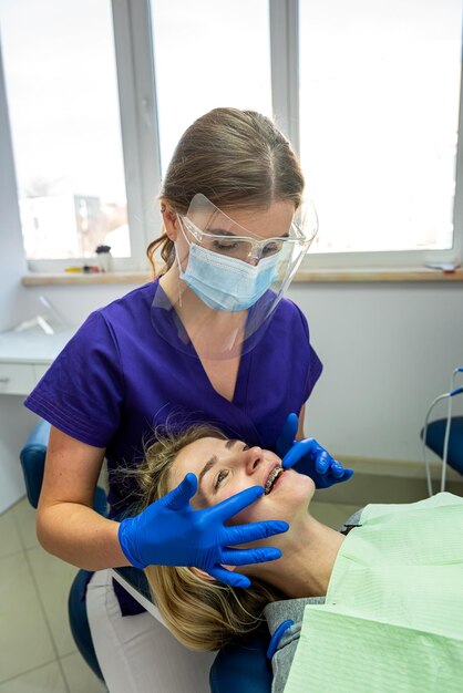 Foto mujer hermosa joven vino a la prestigiosa nueva odontología para tratar los dientes en su propio dentista