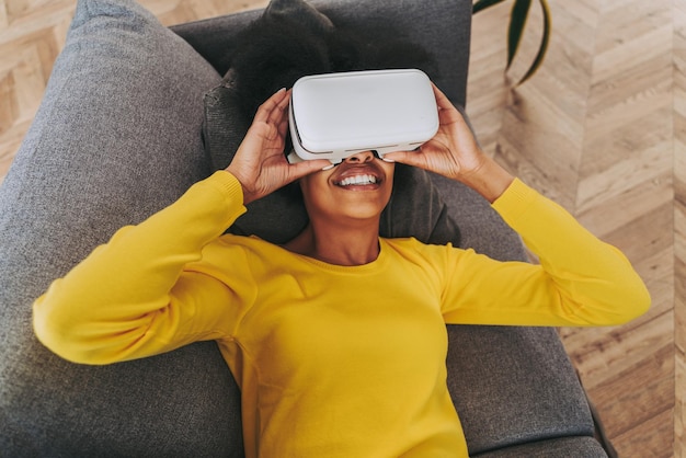 Mujer hermosa jugando en casa con auriculares de realidad virtual