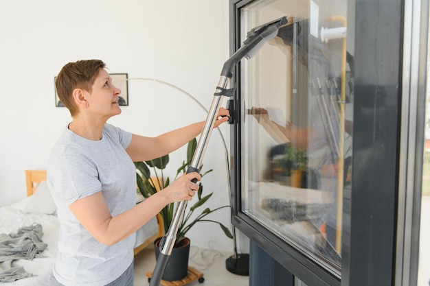 Mujer hermosa limpieza de ventana en casa