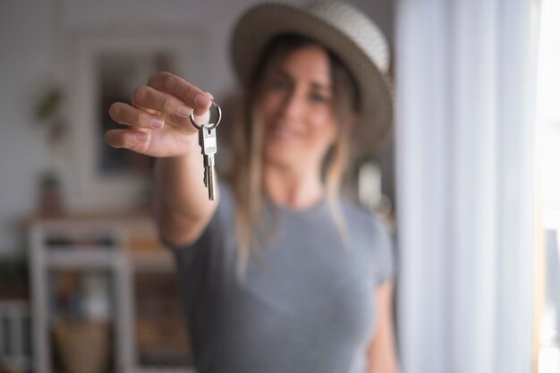 Foto mujer hermosa con llave en casa