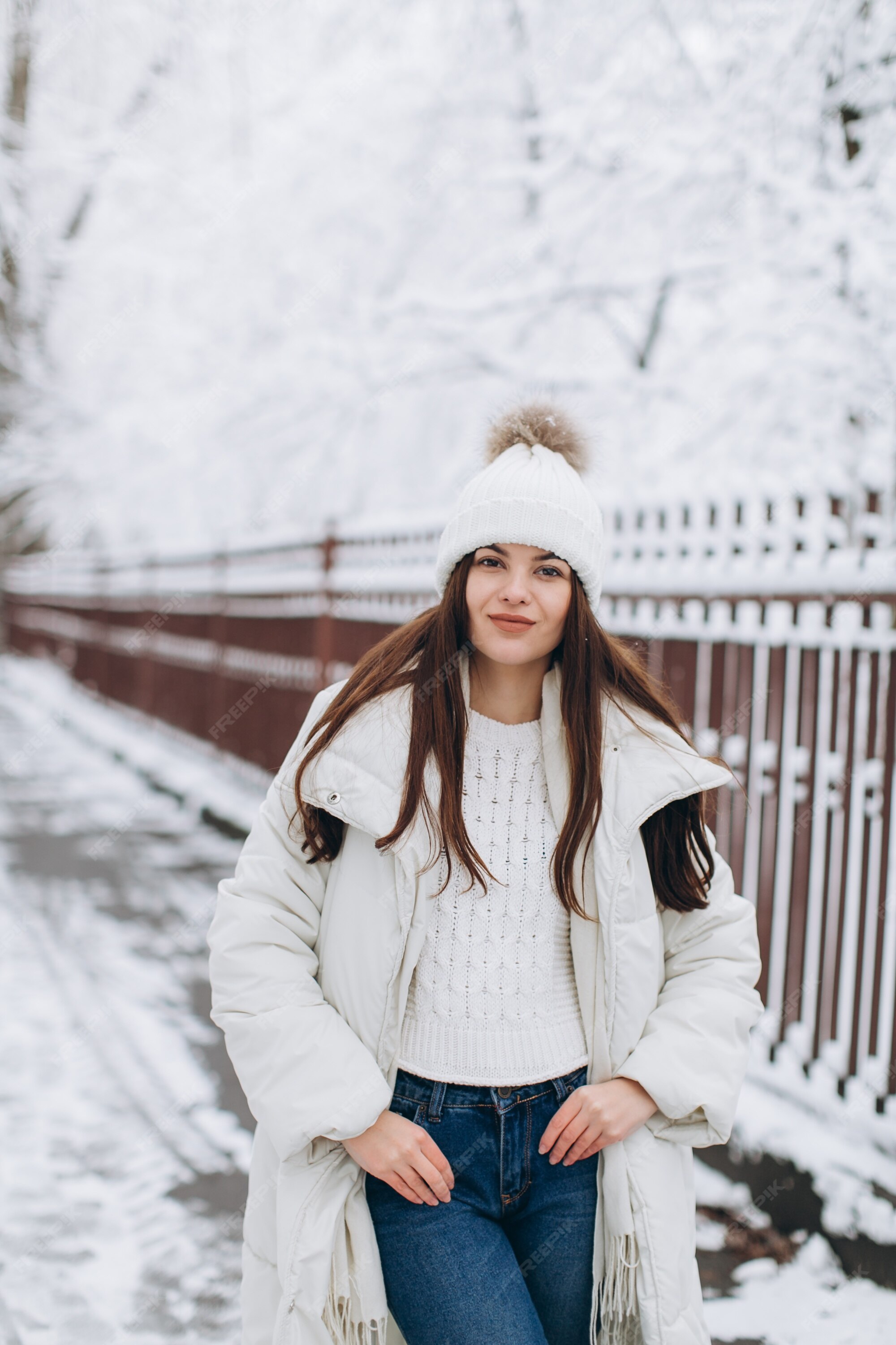 Una mujer hermosa y de moda con ropa blanca y abrigada caminando en clima  nevado. | Foto Premium