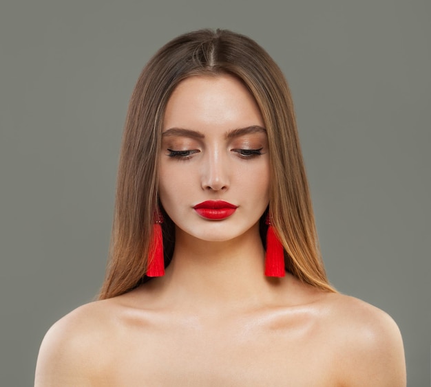 Mujer hermosa modelo de moda con retrato de aretes de joyería roja