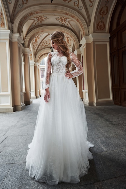 Mujer hermosa novia en un vestido de novia en un castillo encantador.