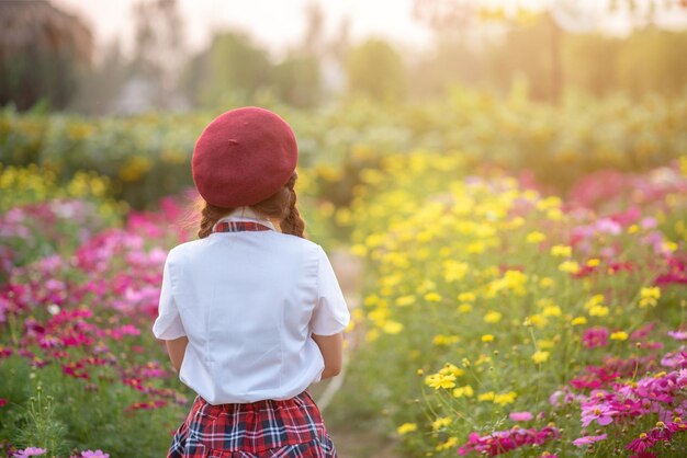 Una mujer hermosa parada en un hermoso jardín de flores por la noche