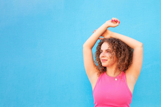 Foto mujer hermosa en la pared de fondo azul en la ciudad feliz sonriente espacio de copia aislado