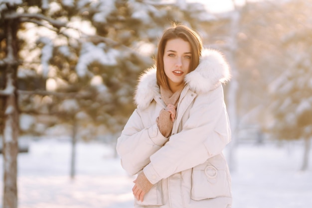 Mujer hermosa en un parque nevado Señorita caminando en un día soleado de invierno