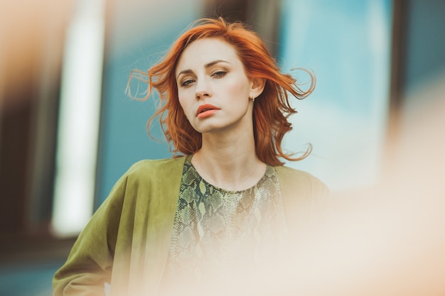 Mujer hermosa pelirroja en una blusa verde