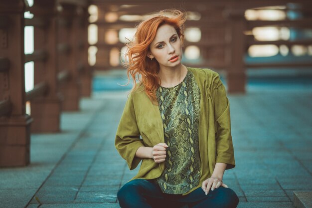 Mujer hermosa pelirroja en una blusa verde