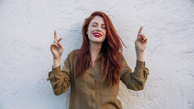 Foto mujer hermosa con el pelo rojo largo chasquido de dedos y bailar disfrutando de escuchar música de pie aga