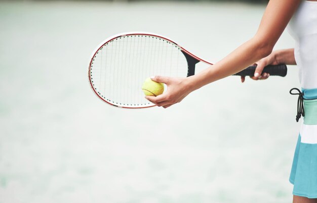 Una mujer hermosa con una pelota de tenis de ropa deportiva