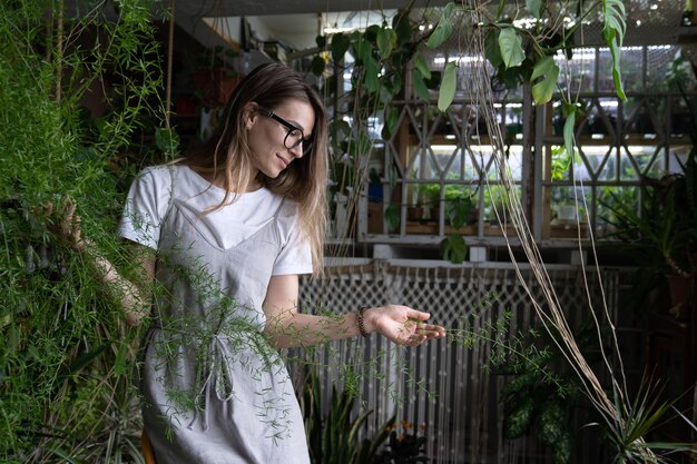 Mujer hermosa de pie junto a las plantas