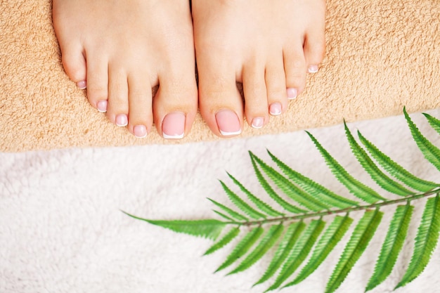 Mujer con hermosa piel de pies y manicura fresca haciendo tratamientos de spa para sus pies