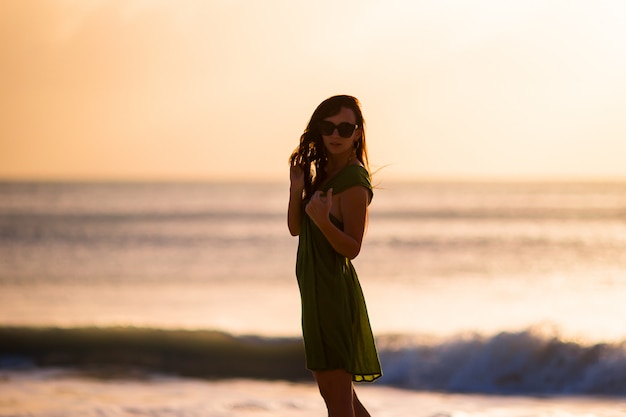 Mujer hermosa en la playa blanca al atardecer.