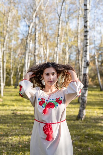 Foto mujer hermosa con ropa tradicional nacional ucraniana caminando por el bosque