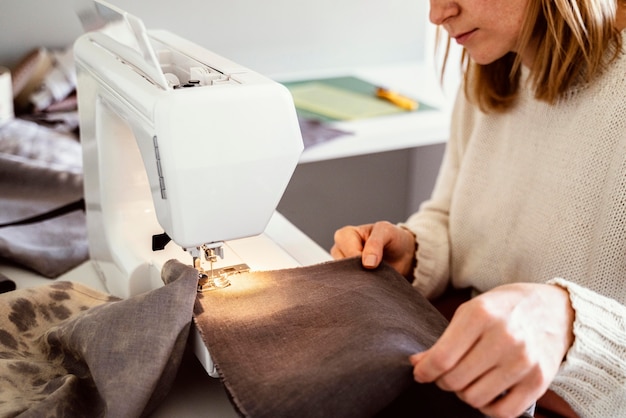 Mujer hermosa sastre con máquina de coser