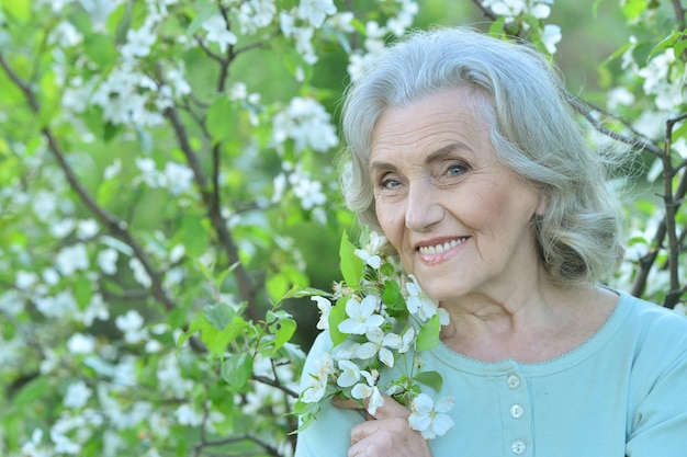 Mujer hermosa senior feliz en el parque de primavera