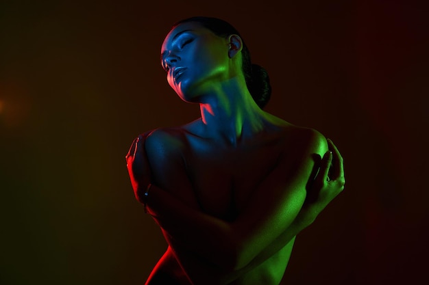 Mujer hermosa silueta femenina en luces de colores